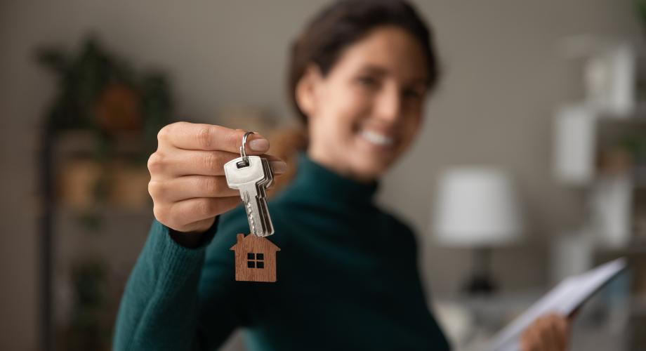woman holding keychain with house on it