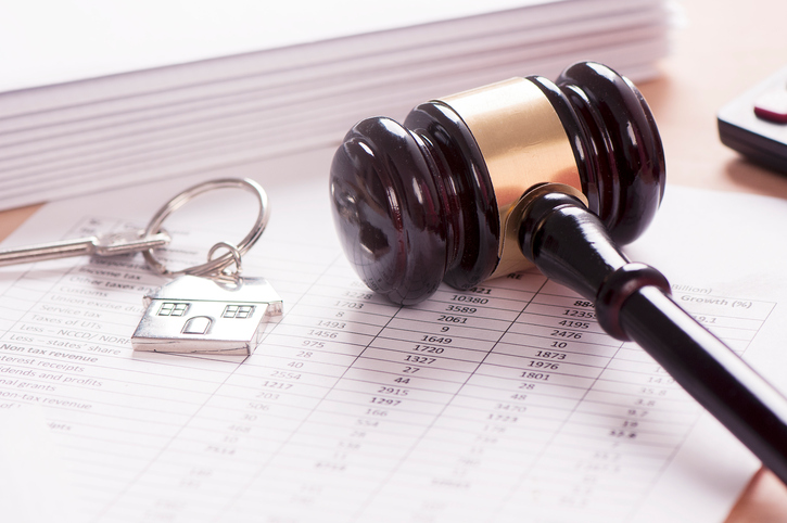 gavel on desk with house key next to it