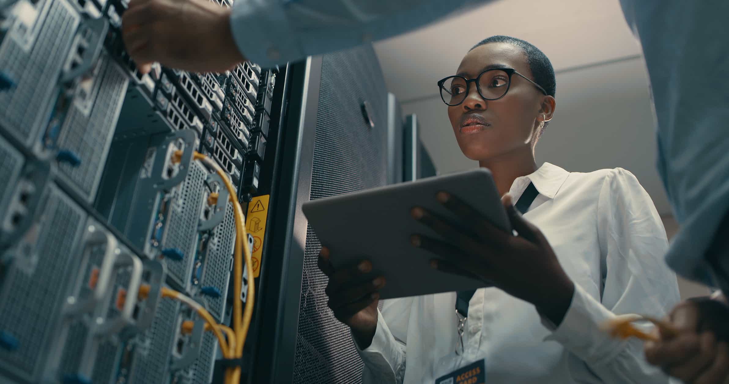 woman using a digital tablet while working in a data center
