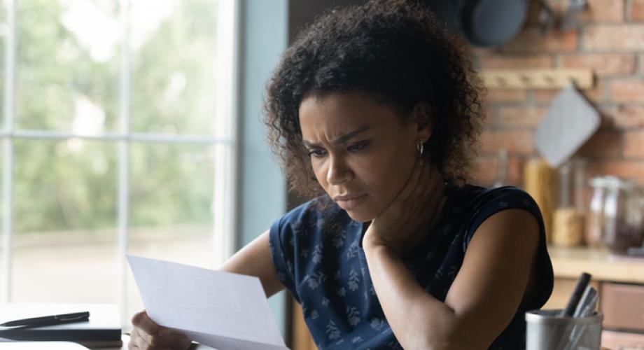 woman reading letter with frustrated or confused face