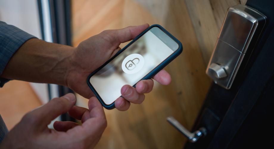 Man opening the door of his house using a home automation system