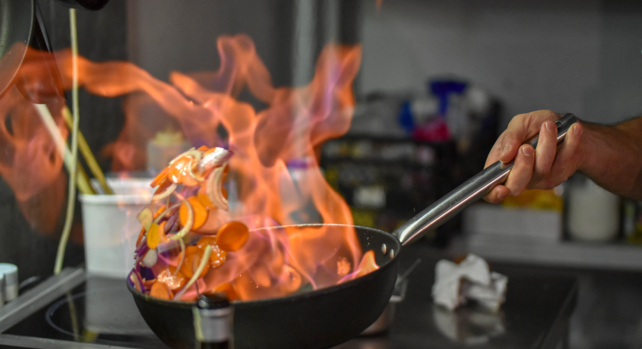 pan with vegetables on fire inside