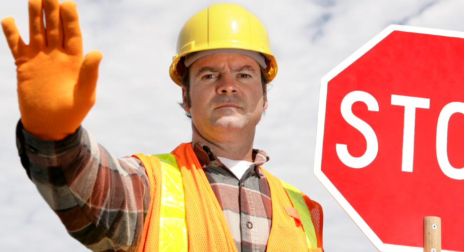 man with a hard hat and stop sign