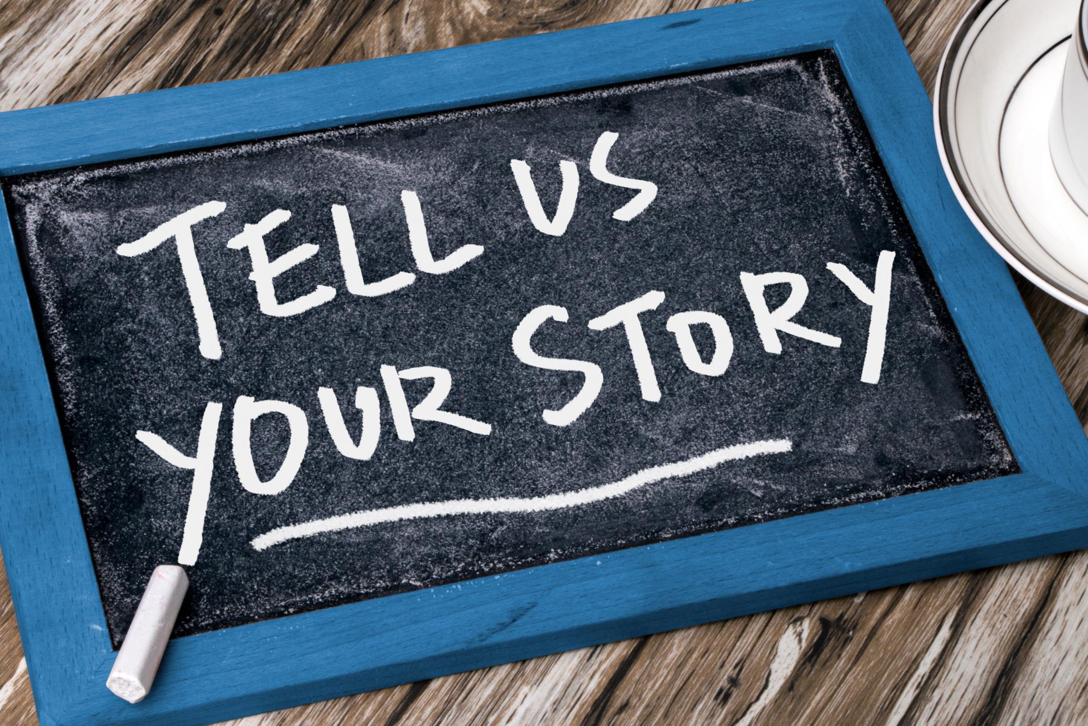 "tell us your story" written on a chalkboard